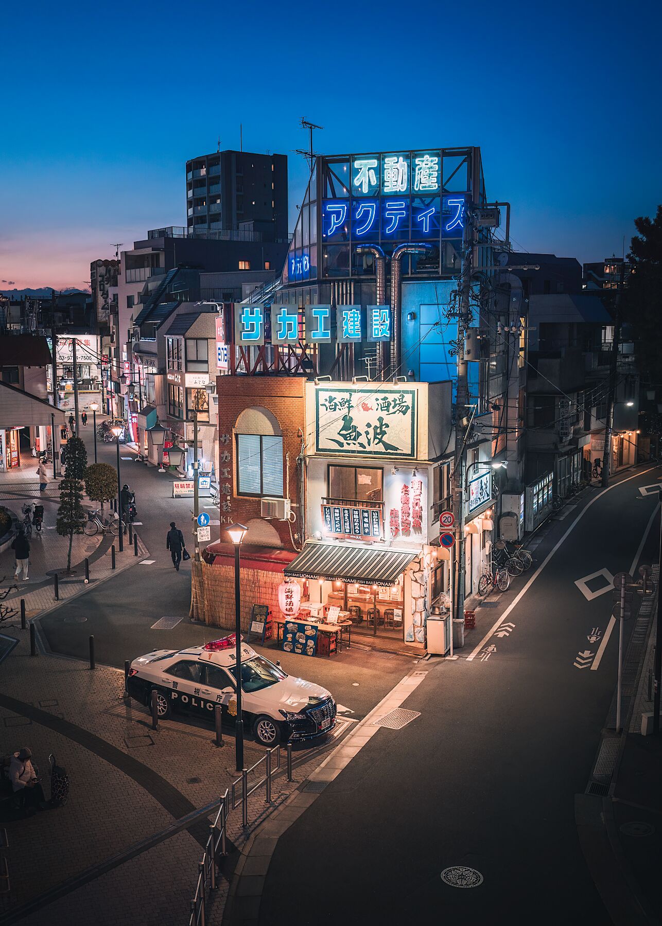 A traditional Japanese izakaya at dusk, glowing with warm lights as the evening begins.