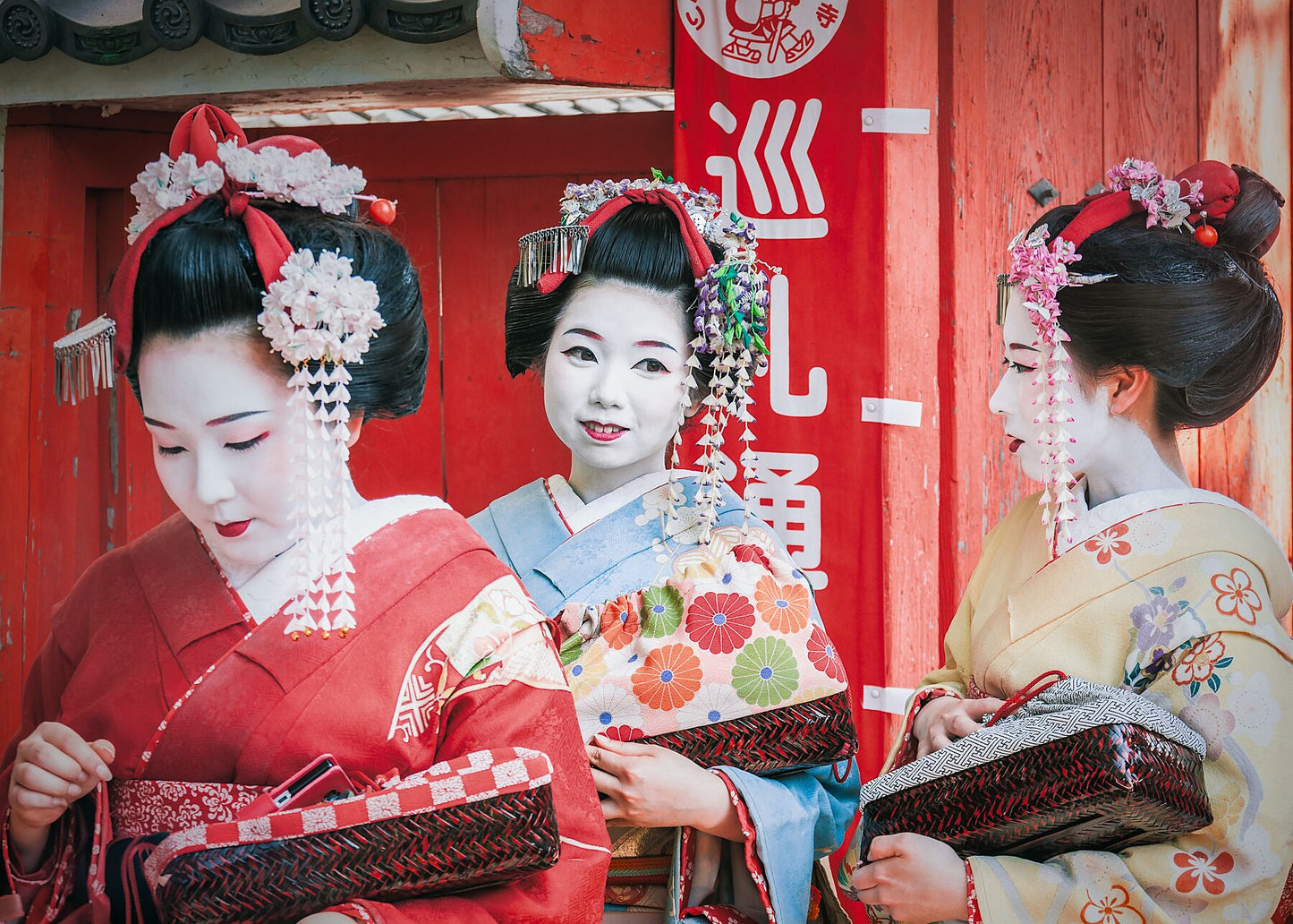 Three Geisha in Kyoto, dressed in traditional kimono, walking gracefully through the streets.