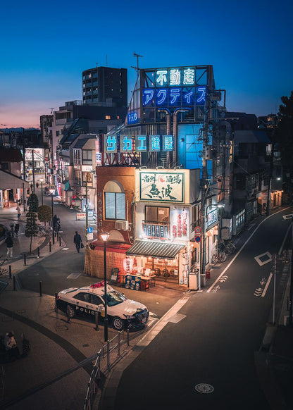 A traditional Japanese izakaya at dusk, glowing with warm lights as the evening begins.