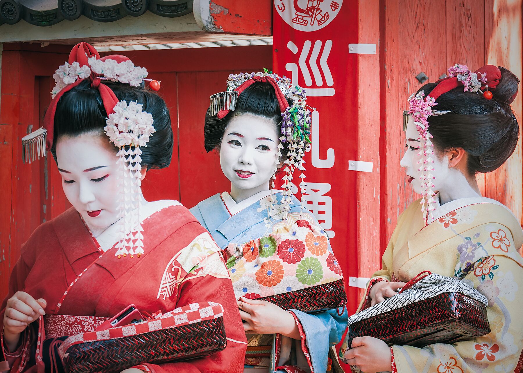 Three Geisha in Kyoto, dressed in traditional kimono, walking gracefully through the streets.